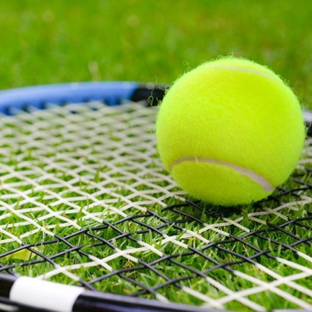 A tennis ball on a racquet.